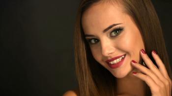 Closeup face of a beautiful smiling girl shows the red nails. Full ...