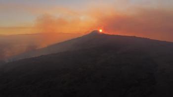 Sunset skyline mountain fire red orange smoke sun sky horizon wide ...