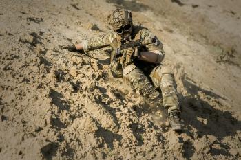Soldier Sliding Downhill Holding Rifle during Daytime