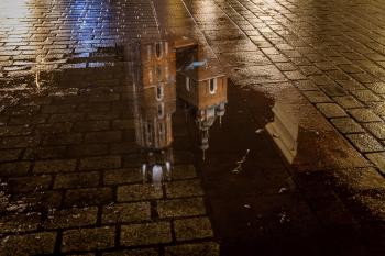 St Mary's Basilica (Kościół Mariacki) reflection in a puddle, Krakow, Poland