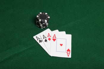 Stack of black poker chips with four ace