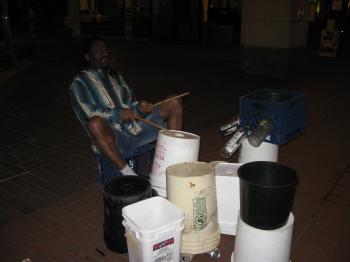 Street performer with ad hoc drums at night