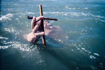 Swimmer holding a cross