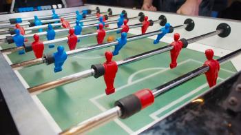 Kick off strike in table football game. Young people playing ...