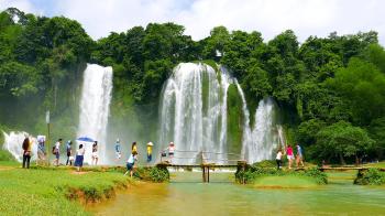 Ban Gioc Waterfall - May 2015: Visitors crossing wooden bridge by ...