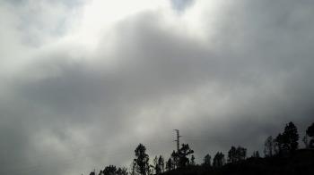 Aerial backwards flight mountain peak trees silhouette and thick ...