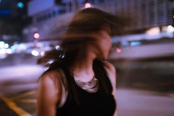 Tilt Shift Photography of Woman Wearing Tank Top during Nighttime