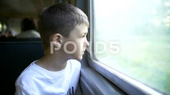 Boy travelling by train looking in the window, Sun rays ~ Hi Res ...