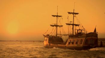 Old medieval ship gracefully sailing to open sea, travelling towards ...