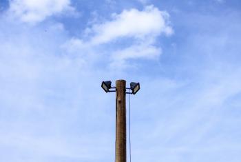 Two spotlights atop a wooden post