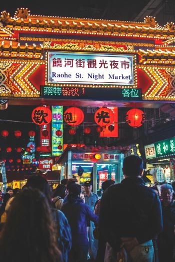 View of Raohe St. Night Market Arch With Kanji Texts and Group of People