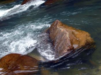 Water over smooth boulders in river
