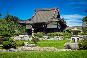 White and Black Temple Surrounded by Green Grass Field during Daytime