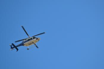 White and blue helicopter flying in the sky