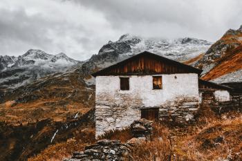 White and Brown House Near Snow Capped Mountains