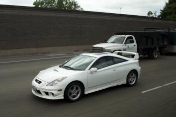 White sports car and truck on highway