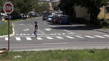 Woman crossing a road at an intersection located on the pedestrian ...