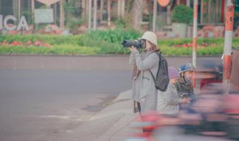 Woman Holding Black Dslr Camera Taking Picture