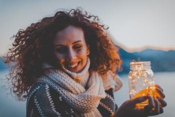 Woman Holding Lighted Jar Smiling