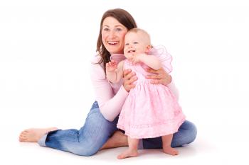 Woman Holding the Waist of Baby Girl in Pink Dress