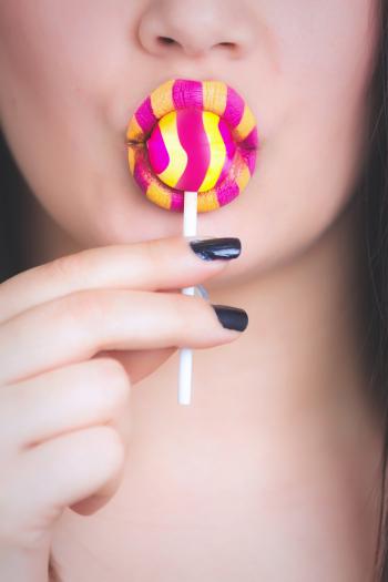 Woman Holding Yellow and Pink Candy