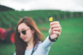 Woman Holding Yellow Petaled Flower