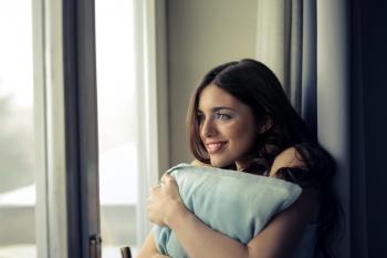 Woman Hugging White Pillow Beside Glass Door