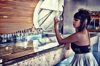 Woman in Black and Gray Backless Dress Sitting in Bar Desk