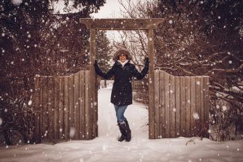 Woman in Black Coat Beside Fence during Snow