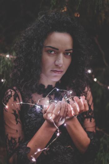 Woman In Black Lace Dress Holding String Lights