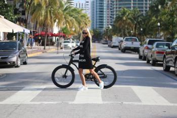 Woman In Black Long Sleeve Shirt Holding Bicycle
