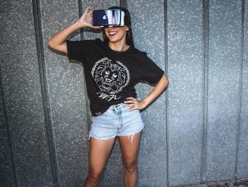 Woman in Black T-shirt Standing and Smiling While Using a Virtual Reality Glasses
