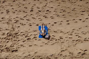 Woman in Blue 2-piece Set Lying on Blue Blanket at Beach on Aerial Photo