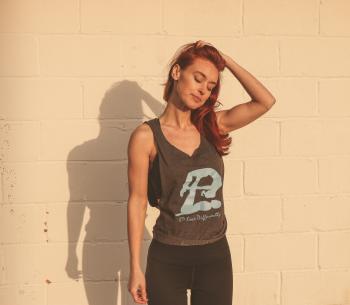 Woman in Gray and Black Tank Top Standing Near Wall
