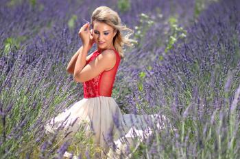 Woman in Red Tank Top With White Mini Skirt Sitting on Grape Purple Hyacinth Field during Daytime