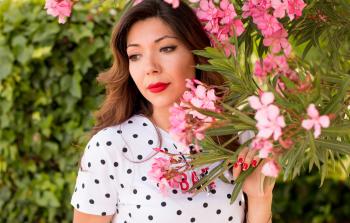Woman in White and Black Polka Dots Dress Near Pink Flowers during Daylight