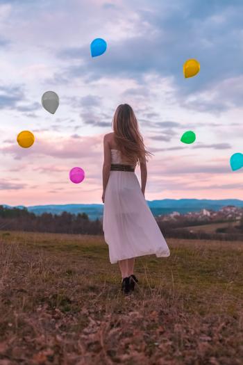 Woman in White Dress Looking at the Balloons