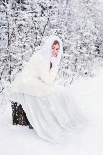 Woman in White Fur Hooded Dress in White Snow Filed