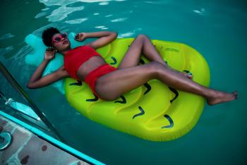 Woman Lying on Green Float Wearing Red Bikini