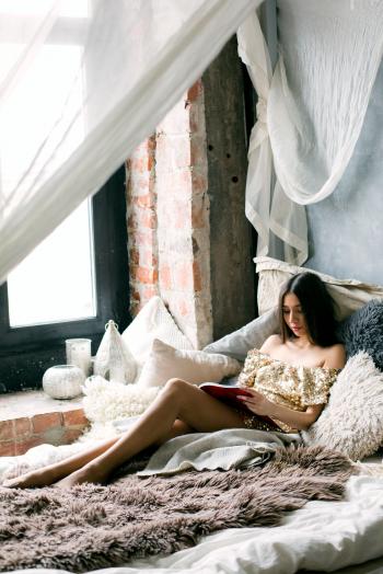 Woman Reading a Book in the Bed