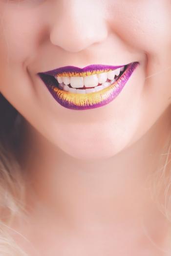 Woman Showing Her Purple and Yellow Lipsticks