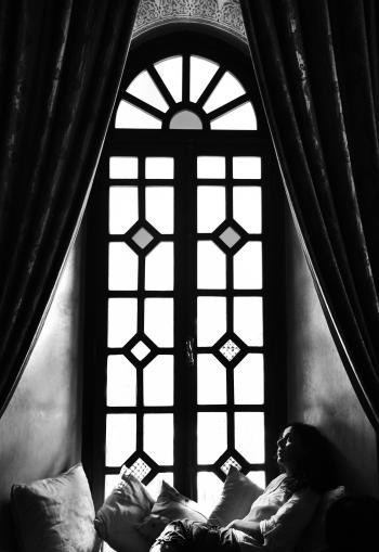 Woman sitting in window sill