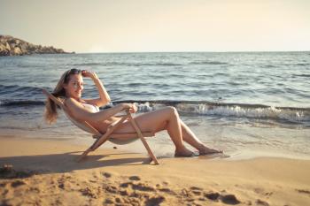 Woman Sitting on Sun Chair Beside Seashore at Daylight Photography