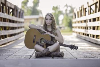 Woman Sitting While Holding Classical Guitar during Daytime