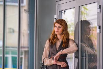 Woman Standing Near Clear Glass Gray Framed Door Panel