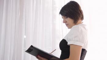 Short hair business Woman standing, taking notes, side view, low ...
