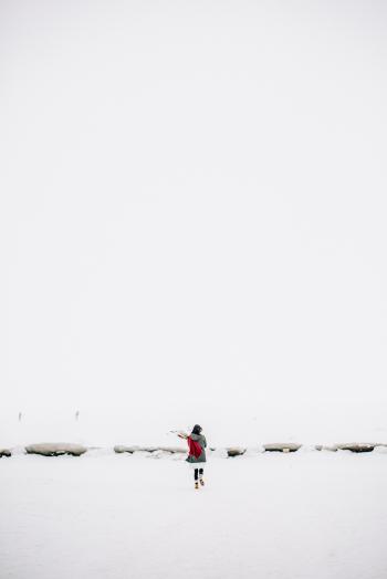 Woman Walking on Snow-covered Field