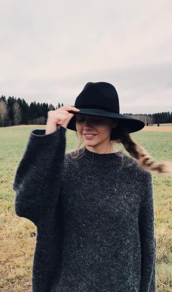 Woman Wearing and Holding Black Summer Hat Outdoor