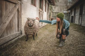 Woman Wearing Beanie Beside Sheep