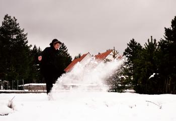 Woman Wearing Black Coat While Playing with Snow